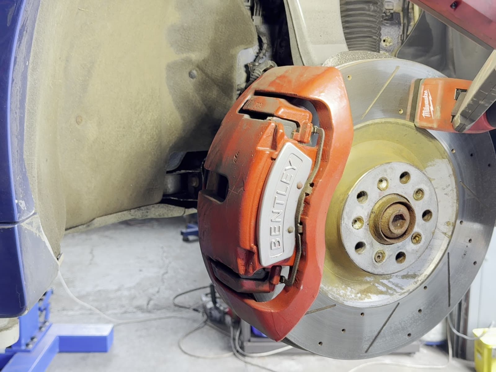 Bentley Onyx GTX 700 front brake caliper and disc dulled with brake dust before dry ice blasting
